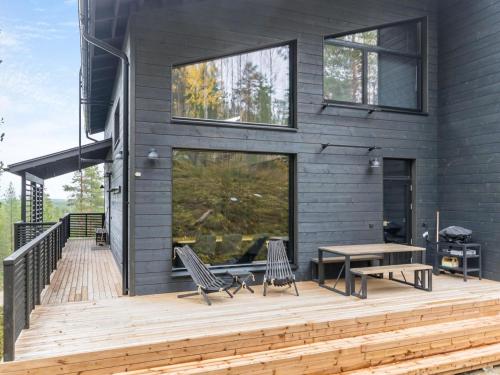 a house with a wooden deck with a table and chairs at Holiday Home Villa arcus a by Interhome in Pelkosenniemi