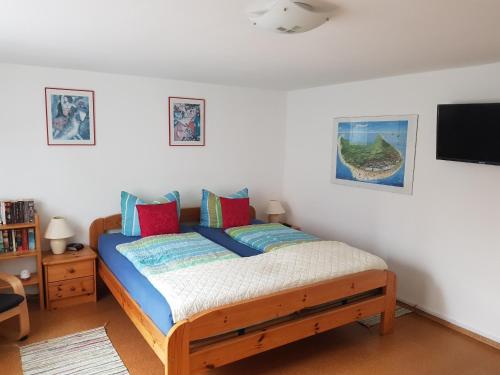 Schlafzimmer mit einem Bett mit blauen und roten Kissen in der Unterkunft Haus Marrakesch in Borkum