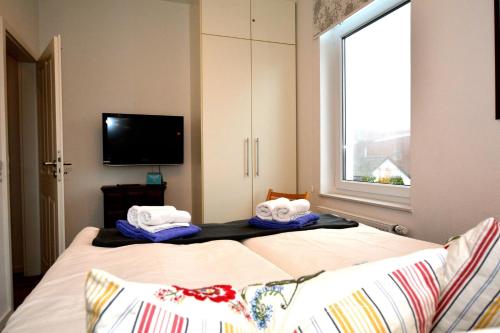 sypialnia z 2 łóżkami i oknem w obiekcie Villa-Pirola-Wohnung-5 w mieście Borkum