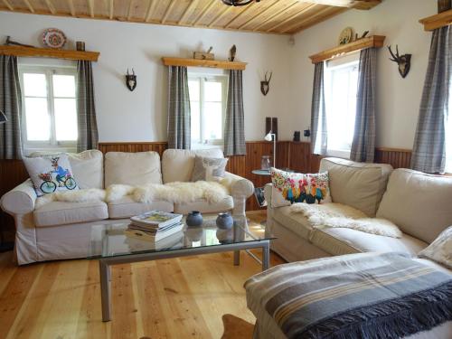 uma sala de estar com dois sofás e uma mesa de vidro em Holiday Home Desná 479 by Interhome em Dolní Polubný