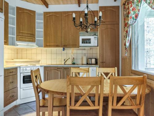 a kitchen with a wooden table and chairs at Holiday Home Hopeatalo b by Interhome in Pyhätunturi