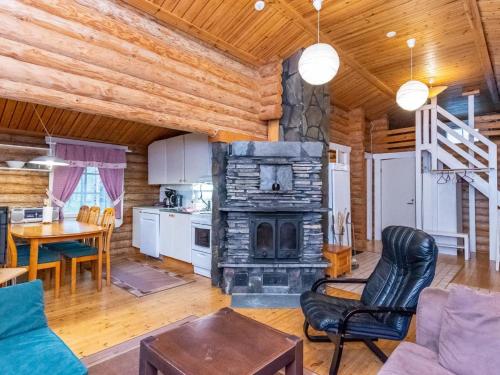 a living room with a fireplace in a log cabin at Holiday Home Hovimartti by Interhome in Pyhätunturi