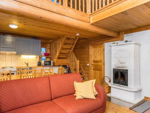 uma sala de estar com um sofá vermelho e uma cozinha em Holiday Home Kuukkelin tupa 2 by Interhome em Pyhätunturi