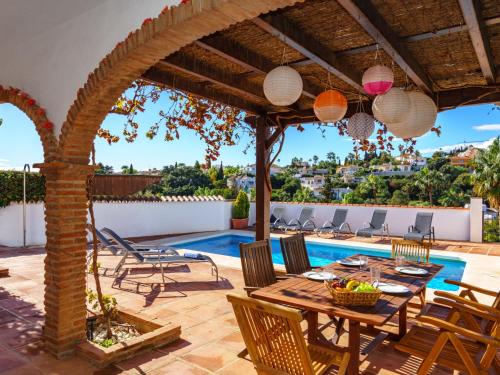 une terrasse avec une table et des chaises ainsi qu'une piscine dans l'établissement Villa Luna by Interhome, à Sitio de Calahonda