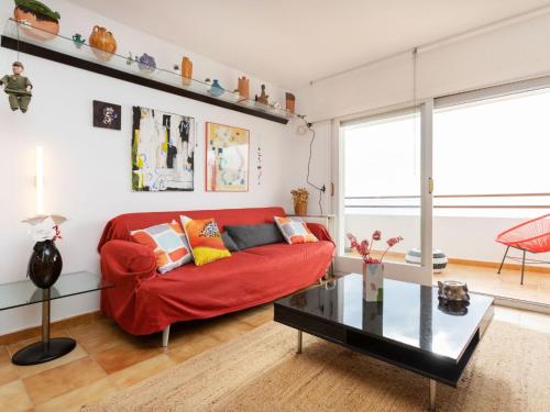 een woonkamer met een rode bank en een glazen tafel bij Apartment Geminis by Interhome in Hospitalet de l'Infant
