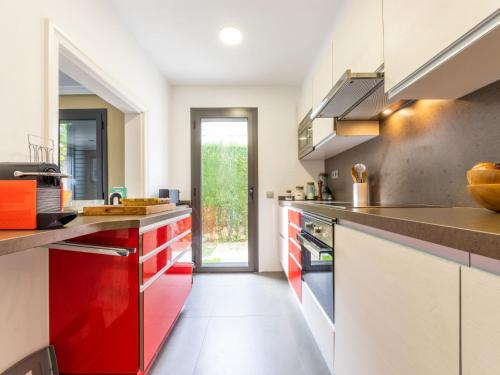 een keuken met rode en witte kasten en een deur bij Holiday Home La Barca by Interhome in Cambrils