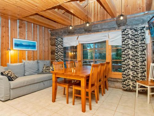 ein Esszimmer mit einem Holztisch und einem Sofa in der Unterkunft Holiday Home Joikupirtti a by Interhome in Pyhätunturi