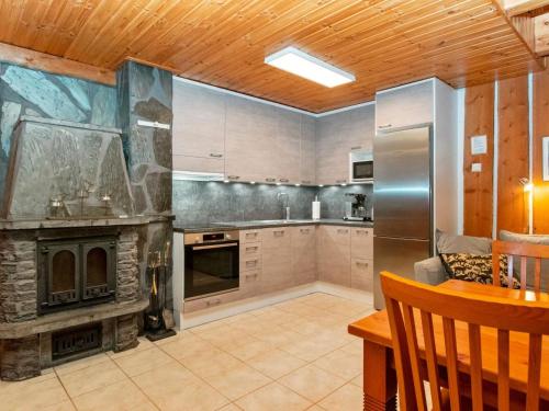 a large kitchen with a large stone fireplace at Holiday Home Joikupirtti a by Interhome in Pyhätunturi