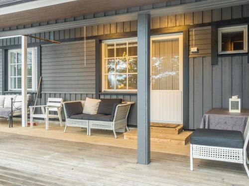een terras met een bank en stoelen in een huis bij Holiday Home Torvokoski by Interhome in Karigasniemi