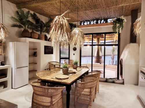 uma sala de jantar com mesa e cadeiras em Buff & Fellow Eco Cabins em George