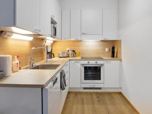 eine Küche mit weißen Schränken und einer Spüle in der Unterkunft Holiday Home Hovikatti by Interhome in Vuokatti