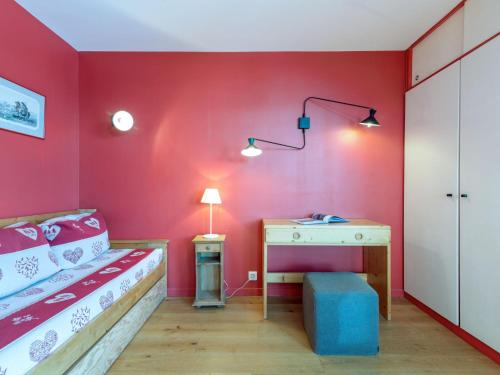 Schlafzimmer mit roten Wänden, einem Bett und einem Schreibtisch in der Unterkunft Apartment Les Roches Rouges by Interhome in Tignes