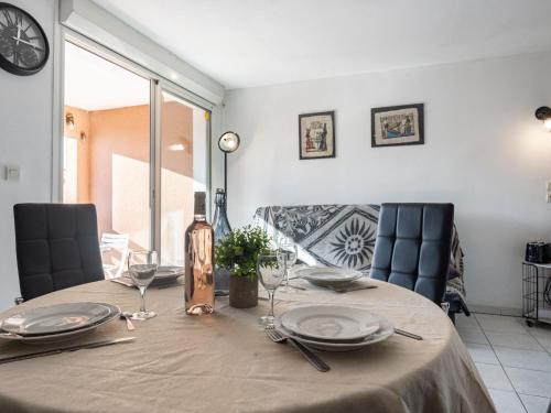 une table de salle à manger avec des assiettes et des verres dessus dans l'établissement Apartment Village Marin Catalan by Interhome, à Torreilles