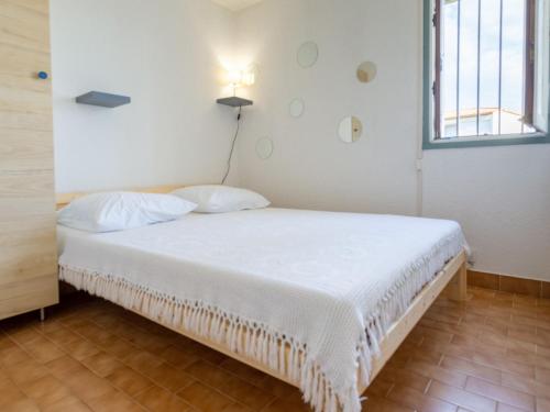un lit blanc dans une chambre avec une fenêtre dans l'établissement Apartment Les terrasses de la Plage-5 by Interhome, au Cap d'Agde