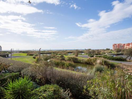 - une vue sur un parc avec une rivière et des bâtiments dans l'établissement Apartment Les terrasses de la Plage-5 by Interhome, au Cap d'Agde