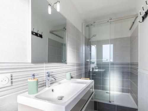 une salle de bain blanche avec un lavabo et une douche dans l'établissement Apartment Coutant-2 by Interhome, à Royan