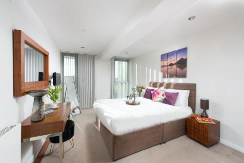 a bedroom with a large bed with a desk and a desk at 22 Zinc in Newquay