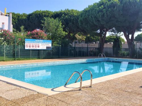 une grande piscine avec un panneau en arrière-plan dans l'établissement Studio Les Floralies II-12 by Interhome, au Grau-du-Roi