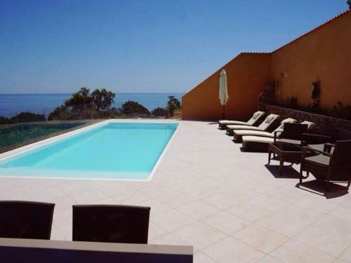 - une piscine avec des chaises et une rangée d'ofitures dans l'établissement Villa Villa Orizonte by Interhome, à Favone