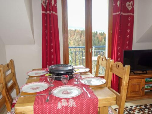 une table à manger avec un tissu de table rouge et blanc dans l'établissement Apartment Le Domaine de Crespin by Interhome, à Saint-Gervais-les-Bains