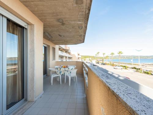 einen Balkon mit Tisch und Stühlen sowie Strand in der Unterkunft Apartment Le Palazzo del Mar-12 by Interhome in Cavalaire-sur-Mer