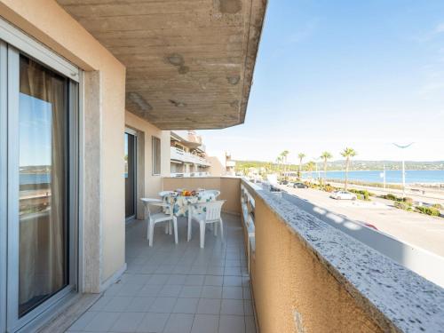 a balcony with a table and chairs and the beach at Apartment Le Palazzo del Mar-12 by Interhome in Cavalaire-sur-Mer