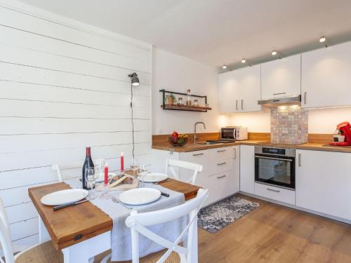 una cocina con mesa y sillas y una cocina con armarios blancos. en Apartment Savoy by Interhome, en Tignes