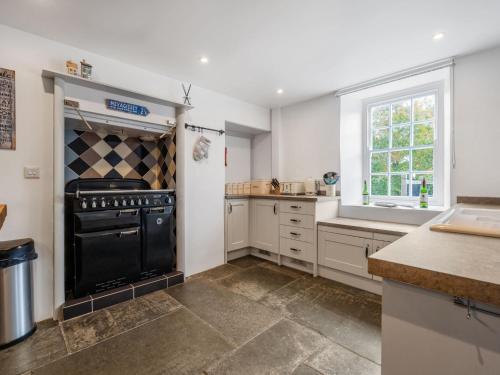 a kitchen with a black stove and a window at Holiday Home Cherry Orchard House by Interhome in Mevagissey