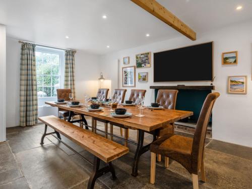 a dining room with a table and chairs and a television at Holiday Home Cherry Orchard House by Interhome in Mevagissey