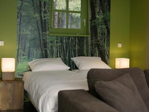 2 camas en un dormitorio con paredes verdes y ventana en De Swarte Ruijter, en Holten