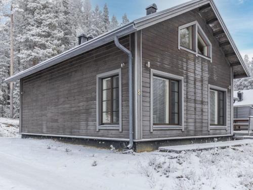uma casa de madeira na neve com árvores em Holiday Home Pyhänkarhu 3 by Interhome em Pyhätunturi