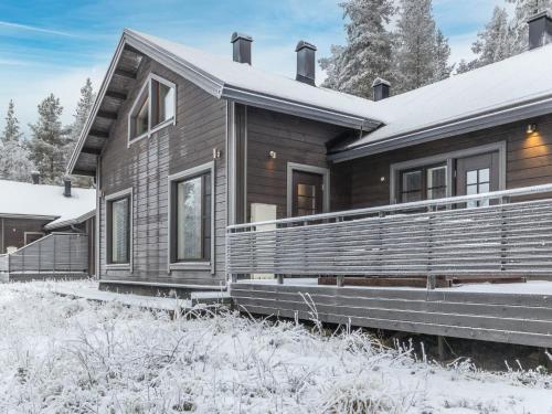 uma casa de madeira com neve no chão em Holiday Home Pyhänkarhu 3 by Interhome em Pyhätunturi