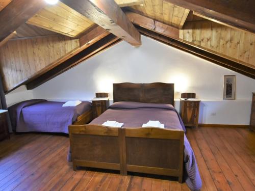 1 dormitorio en el ático con 2 camas y suelo de madera en Studio Albergo Diffuso - Cjasa de Pagnocca-5 by Interhome, en Barcis