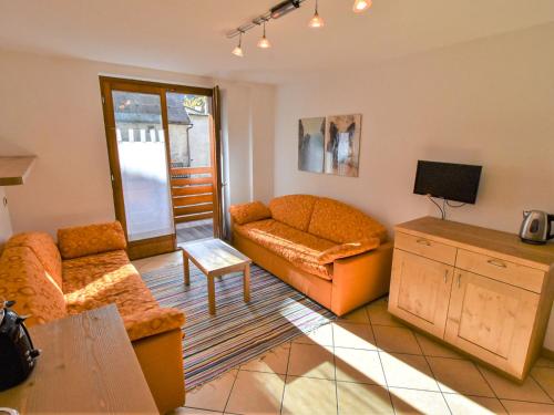 a living room with a couch and a tv at Apartment Cà Serena by Interhome in Campodolcino