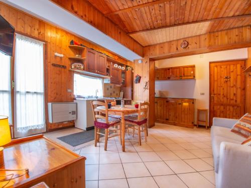 una cocina con armarios de madera, mesa y sillas en Apartment La Collina by Interhome en Rivisondoli