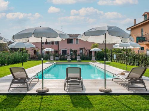 a swimming pool with chairs and umbrellas at Apartment Al Bistrot dei Vinai-6 by Interhome in Imperia