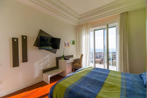 Schlafzimmer mit einem Bett, einem Schreibtisch und einem Fenster in der Unterkunft Panacea in Salerno