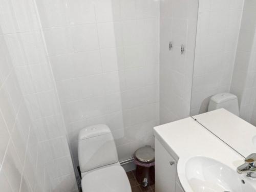 a white bathroom with a toilet and a sink at Holiday Home Sallan lumous b by Interhome in Salla