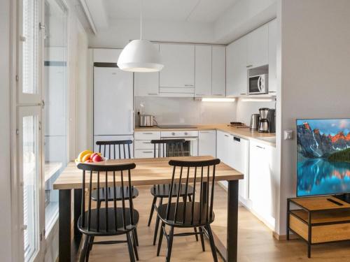 eine Küche mit einem Holztisch und einigen Stühlen in der Unterkunft Holiday Home Jymykatti by Interhome in Vuokatti