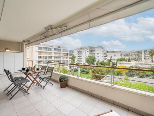 d'un balcon avec une table et des chaises offrant une vue sur la ville. dans l'établissement Apartment Cristal Croisette-4 by Interhome, à Cannes