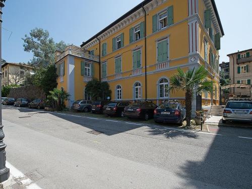 a large yellow building with cars parked in front of it at Apartment Villa Nicole by Interhome in Arco