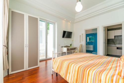 een slaapkamer met een bed met een gestreepte deken bij Panacea in Salerno