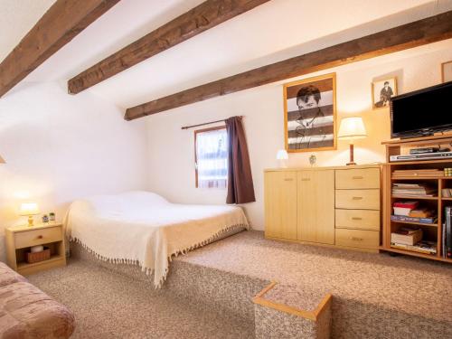 une chambre avec un lit et une commode avec une télévision dans l'établissement Apartment Front de Mer-23 by Interhome, au Barcarès