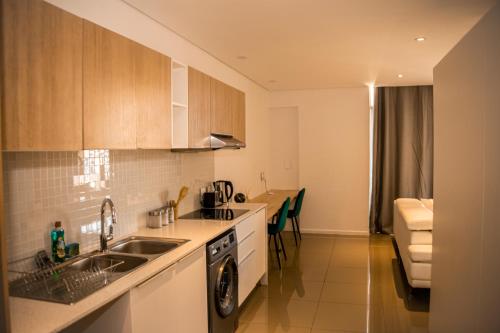 a kitchen with a sink and a stove top oven at Urban Oasis Apartments at Freedom Plaza in Windhoek