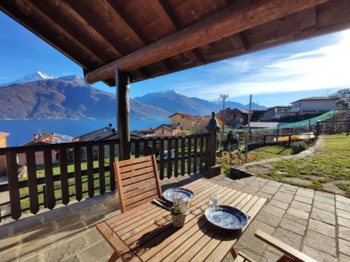 a wooden table and chair on a deck with a view of mountains at Holiday Home Il Crotto by Interhome in Pianello Del Lario