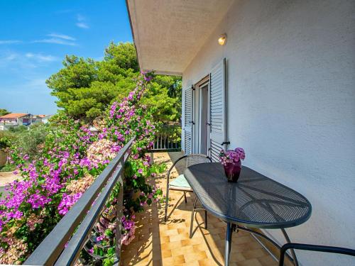 a balcony with a table and some purple flowers at Holiday Home Gabi by Interhome in Brodarica
