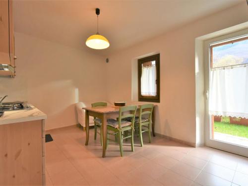 una cucina e una sala da pranzo con tavolo e sedie di Apartment Albergo Diffuso - Cjasa de Pagnocca-2 by Interhome a Barcis