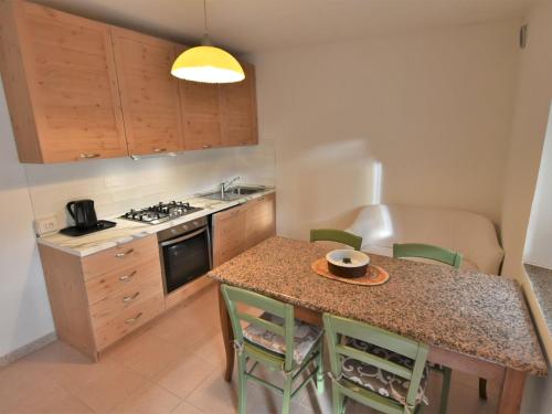 una cucina con tavolo, sedie e lavandino di Apartment Albergo Diffuso - Cjasa de Pagnocca-2 by Interhome a Barcis