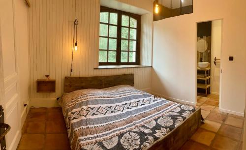 a bedroom with a bed with a blanket on it at Domaine du Moulin in Mouzieys-Teulet
