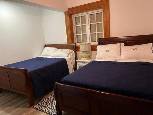 een slaapkamer met 2 bedden en een raam bij Hermosa villa en Jarabacoa in Jarabacoa